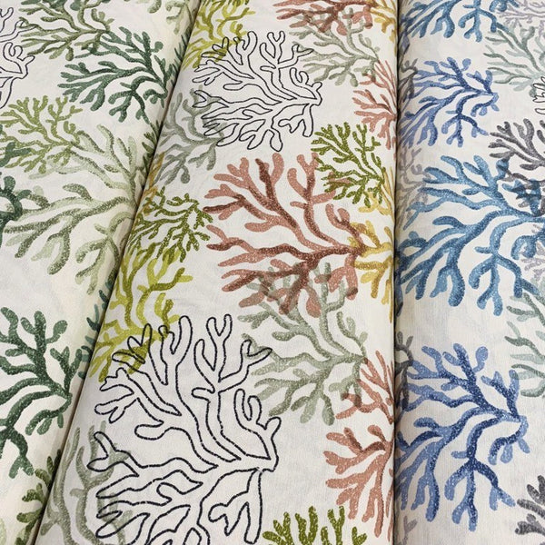 3 rolls of ocean upholstery fabrics patterned with respectively green, yellow and blue coral reefs.