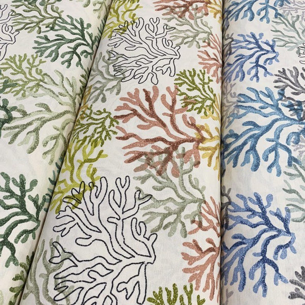 3 rolls of ocean upholstery fabrics patterned with respectively green, yellow and blue coral reefs.
