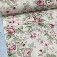 Cream upholstery fabric patterned with pink roses and green leaves.