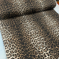 Brown leopard print fabric suitable for upholstery and home decor.