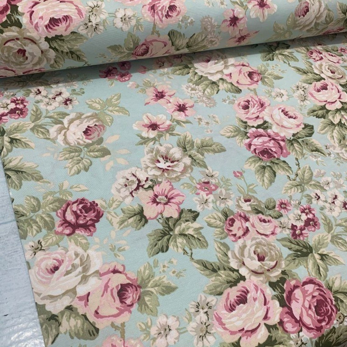 Roses upholstery fabric with a shabby chic floral pattern in pastel colors, primarily pink and mint green.