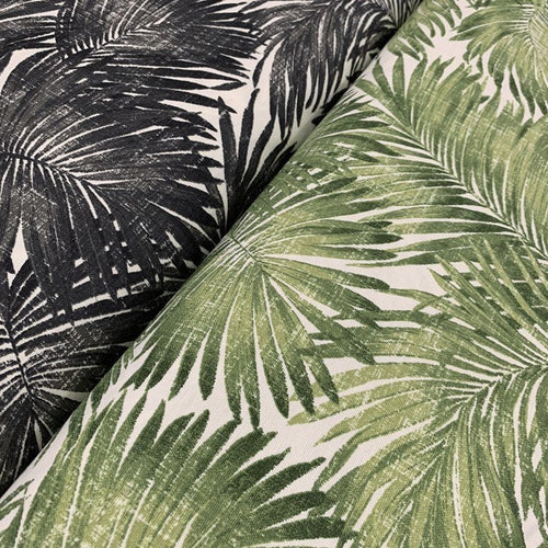 Two pieces of fabric with a tropical palm leaf pattern, one in green and the other in black, laid next to each other.